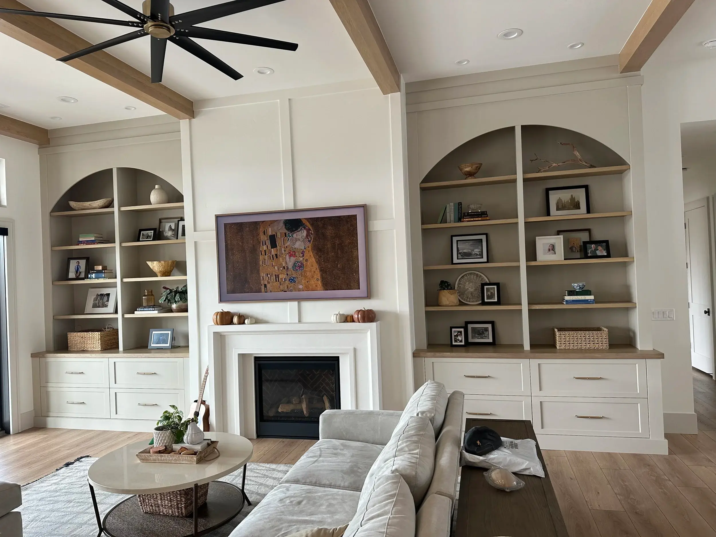 Custom built-in shelving and cabinetry flanking an arched fireplace surround