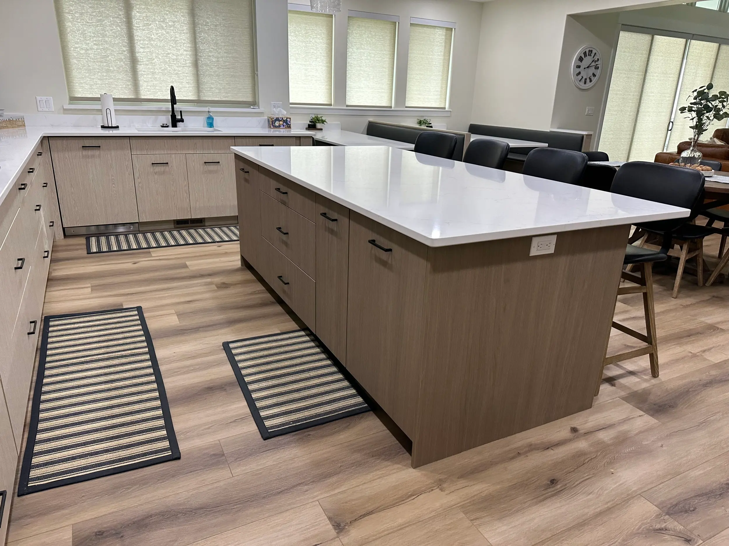 Handcrafted kitchen island with bar-height overhang for seating, built by the cabinet shop with fine joinery detail beneath the countertop.