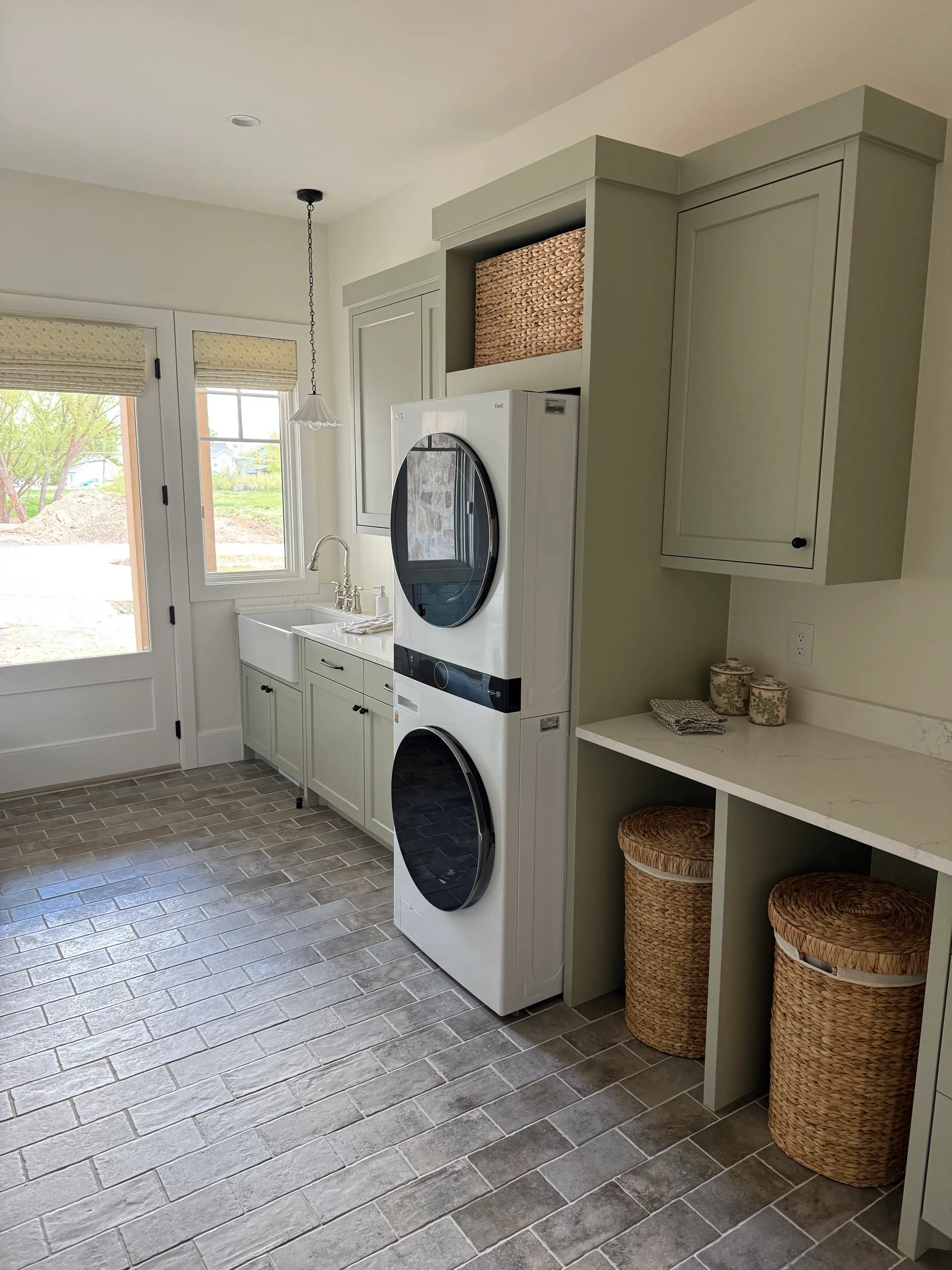 Built-in laundry cabinetry designed around a stacked washer and dryer, with concealed appliance housing and custom overhead storage.