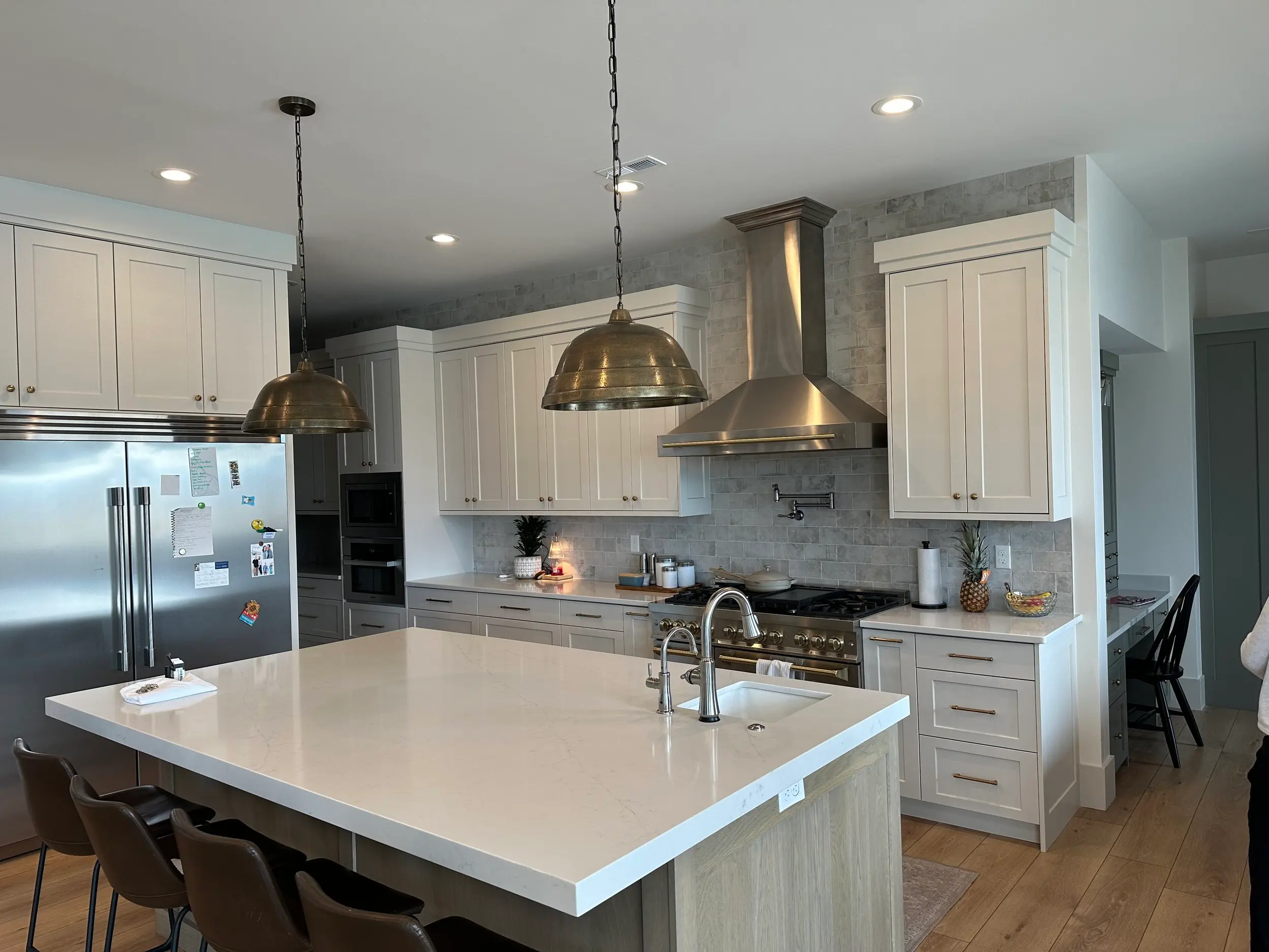 Custom-built white kitchen island with bar seating, shaker cabinet doors, and mountain-view sightline in a bespoke kitchen build.